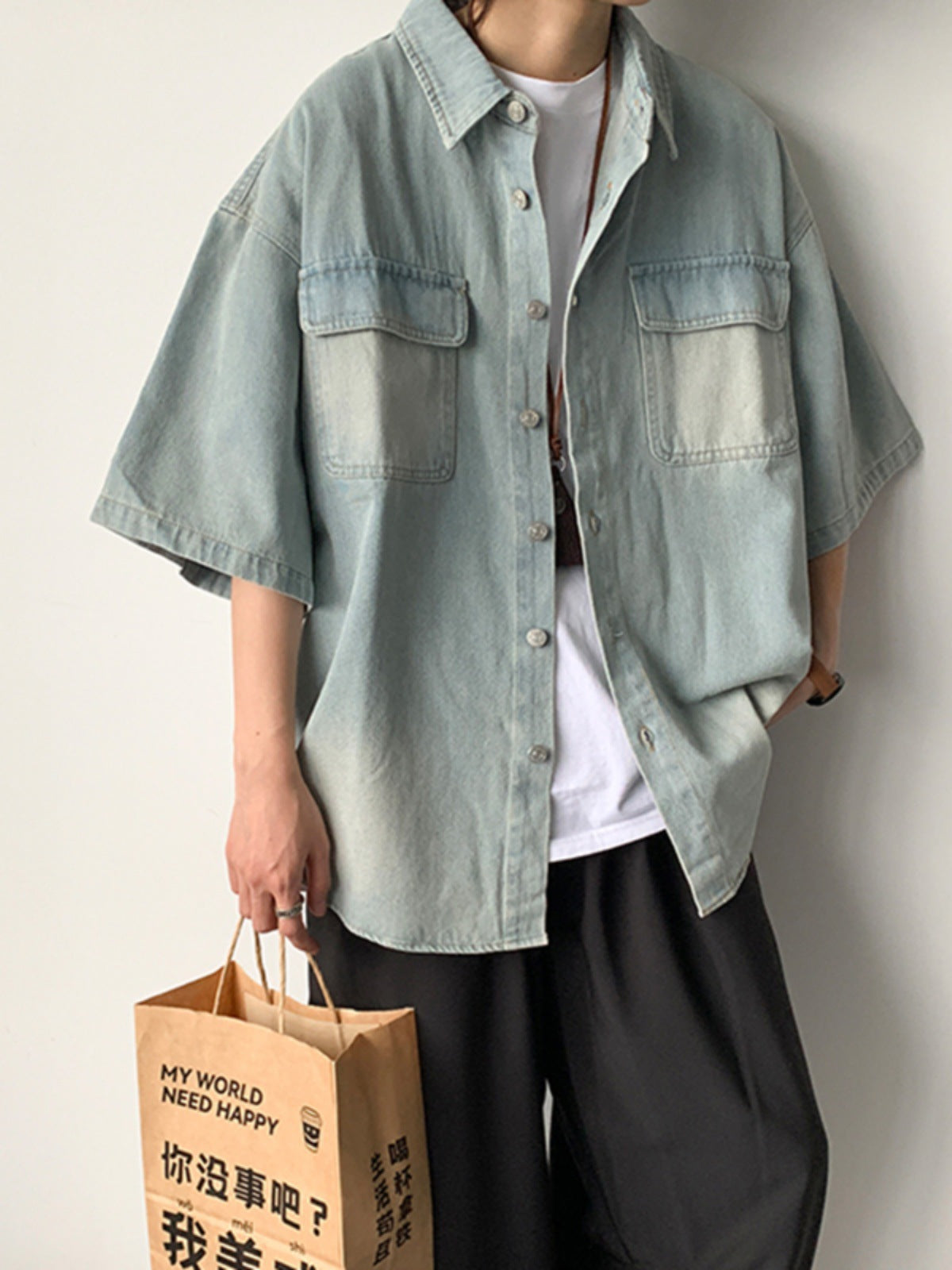 Erabyte Men's Denim Short Sleeve Shirt Jacket in light blue with two chest pockets, worn casually with loose black pants.